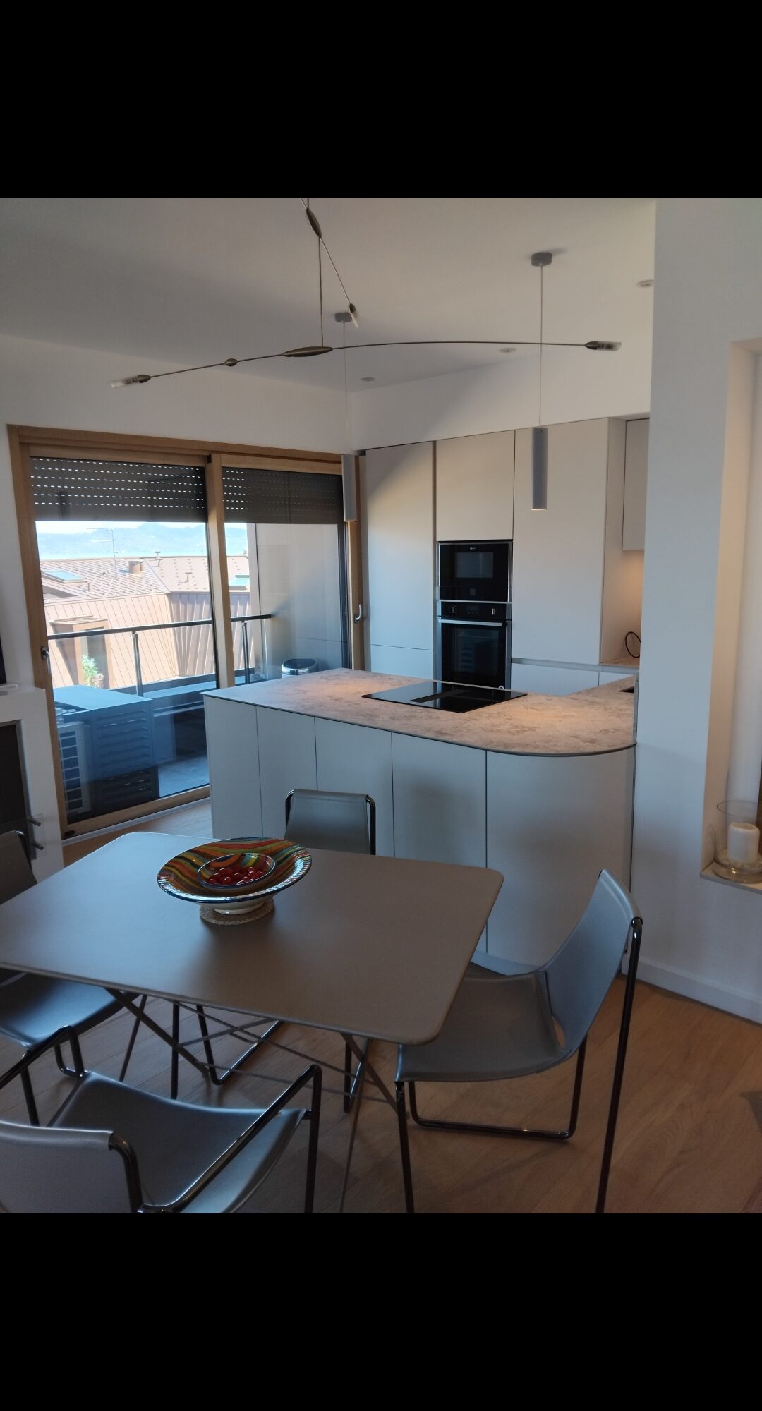 Nouvelle réalisation à Evian : Cuisine Matera blanc coquille, poignées gorge blanc coquille, plan de travail compact noir Thann